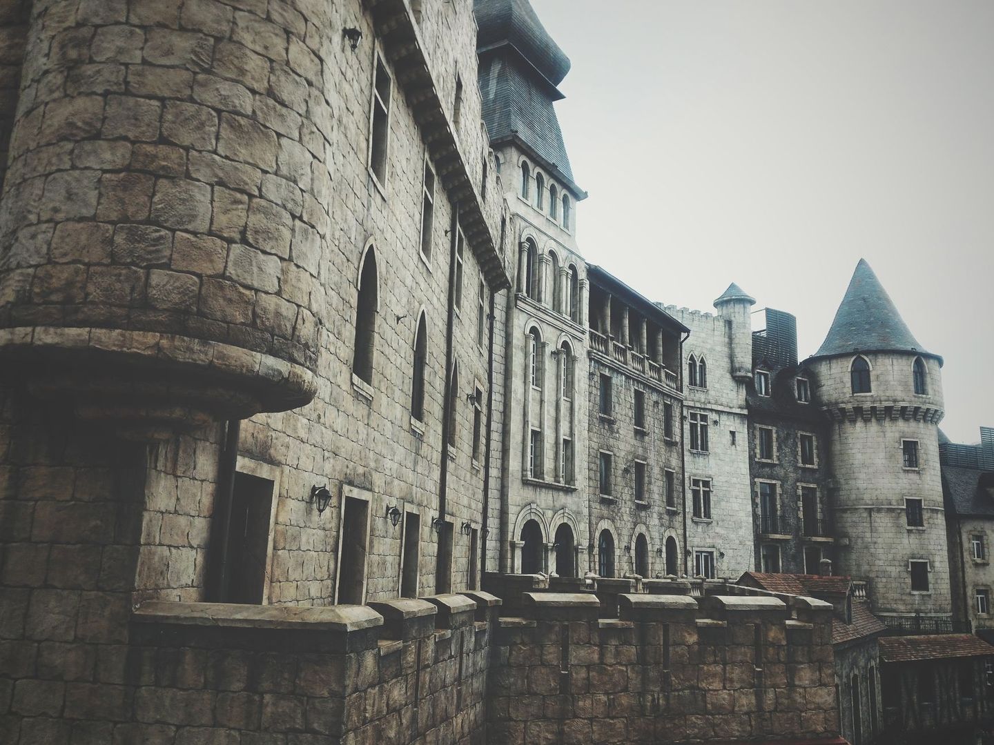 Stone fortress buildings with towers, arched windows, and defensive walls